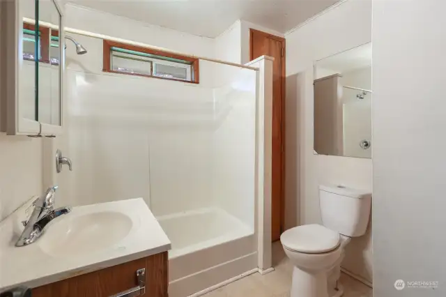 Full bath in hallway, with quite a bit of built-in storage.
