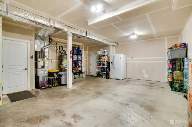 Downstairs, the deep garage accommodates two cars parked in tandem and offers ample storage space. The backdoor leads to the back patio.