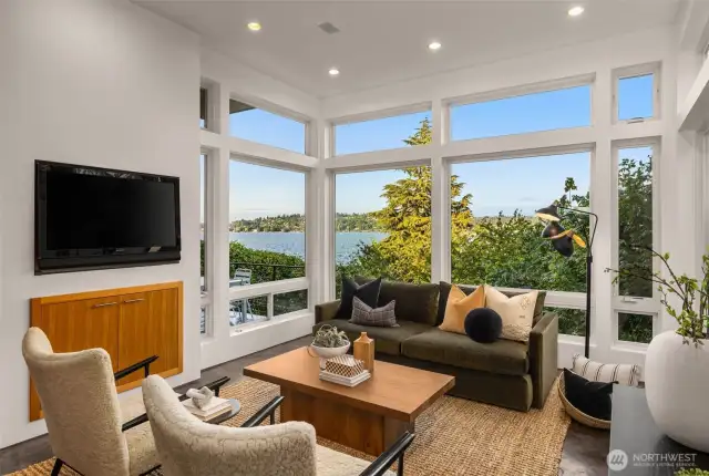 Living room views from the main floor. The living room features floor to ceiling windows, milestone flooring, radiant heat, gas fireplace and custom built-in cabinets.