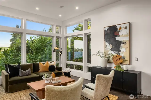 Living room views from the main floor. The living room features floor to ceiling windows, milestone flooring, radiant heat, gas fireplace and custom built-in cabinets.