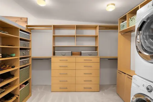 Custom walk-in closet features a washer/dryer and new carpet.