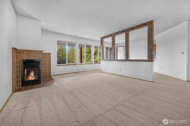 The living room/dining room features a wall of windows flooding the rooms with natural light and offering views of the lake.