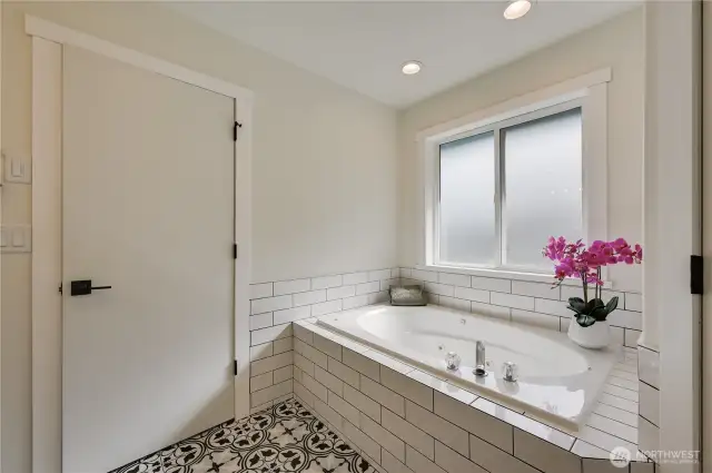 Soaking tub in primary suite.  Walk in shower to the right.