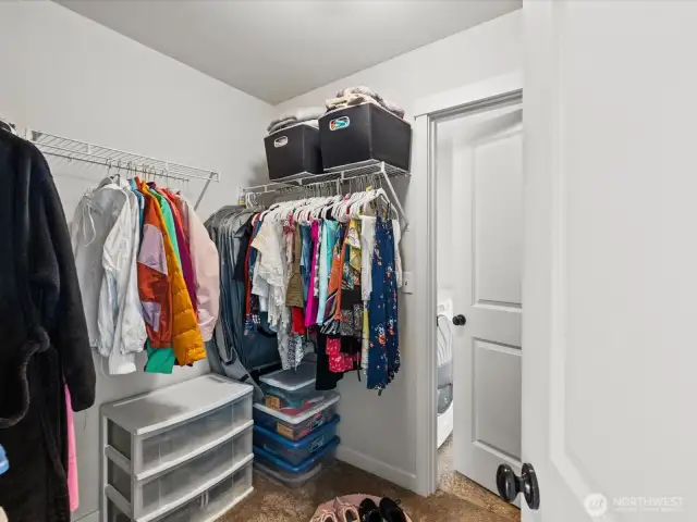 Walk-in closet in primary with door leading to laundry room