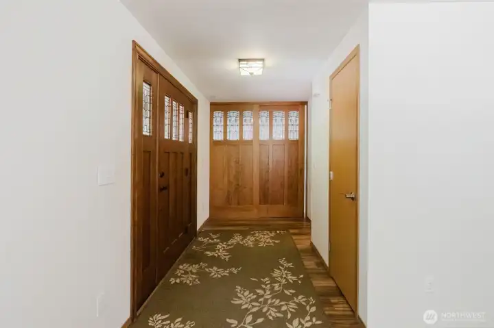 Entryway shows off the nod to the Craftsman vibe wth custom built doors that lead to the bonus room.  These cherry wood doors are floor to ceiling and are set on a sliding track to allow the broad doorway to be fully open as needed.