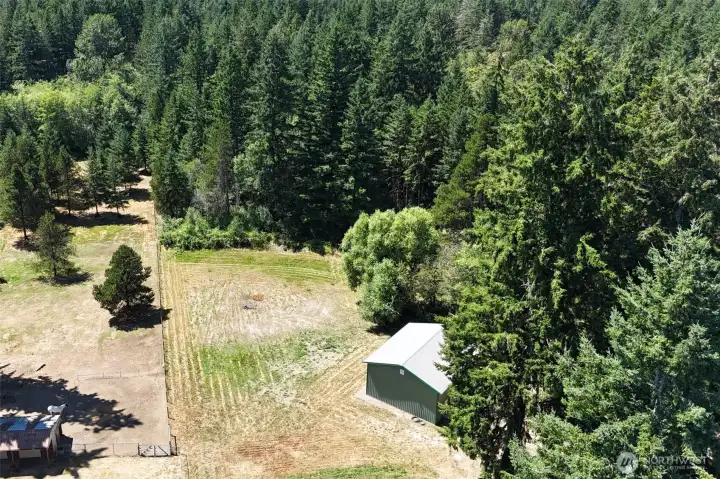 Shop to the right and cleared portion of the backyard.  The woods beyond are the beginning of your own private woods.  You can fit 3 1/2 football fields on this property so the pictures don't include the entire scope of the size!