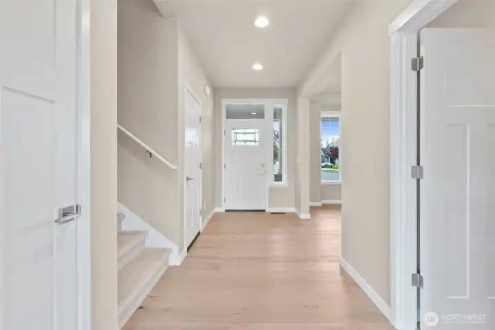 Open and inviting entryway! The front door with transom window above allows natural light to stream in and brighten the space