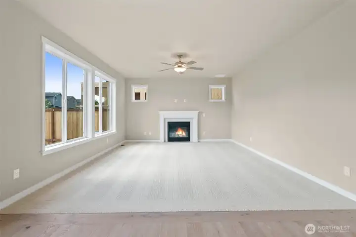 Spacious and inviting great room with a clean, modern design and gas fireplace including a ceiling fan.