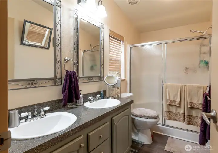 The primary bathroom features a double vanity and walk-in shower with seat.
