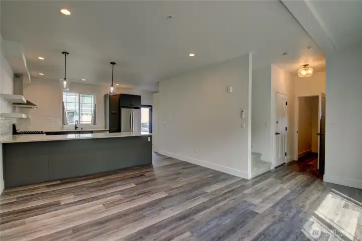 this photo shows a portion of the living room and to the right is the entry from garage, 1/2 bath and stairwell