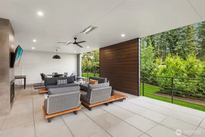 The main level luxury paver patio is an extension of the living room. Large enough for full seating and dining, the  ceiling fan, heaters, and dual fireplace makes for year round enjoyment.