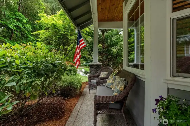 Covered porch with water drip system for hanging plants.
