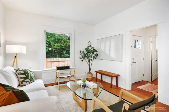 Spacious living room with real fir floors, tall ceilings, updated windows and the perfect balance of privacy + natural light.