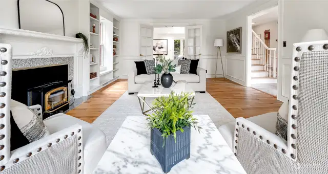 The living room is illuminated by natural light and flows seamlessly to the family room via French doors.