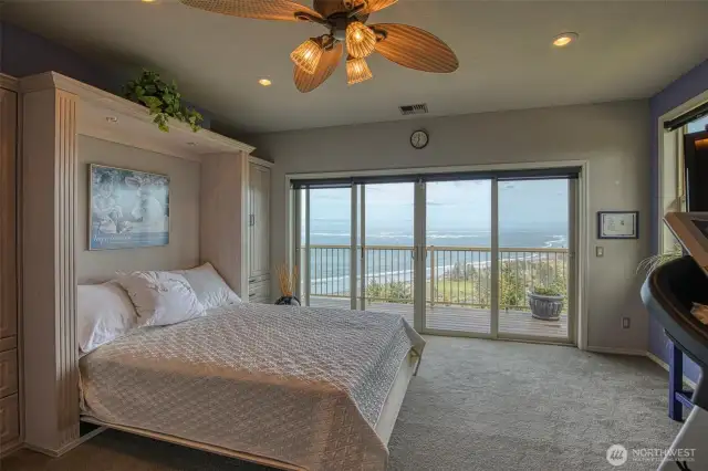 Upper level bedroom features a handy folding wall bed for extra daytime space. The sliding glass doors lead you out to the upper balcony/deck to enjoy the sunshine and ocean views.