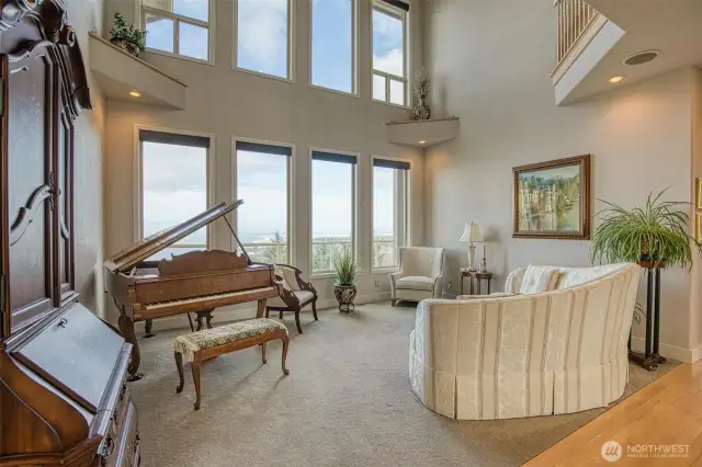 Living room is spectacular with its wall of windows facing the ocean and sky high ceilings affording views from both levels of the home.