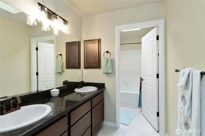 Well-appointed full bath with dual sinks and convenient shower/tub combo.