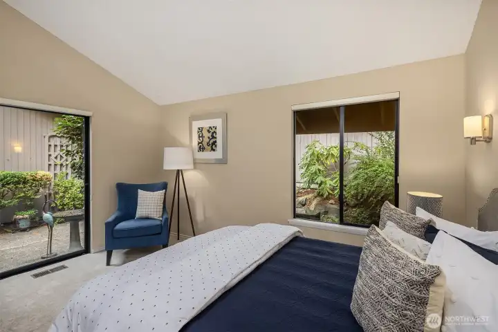 Another view of the primary bedroom, highlighting its tranquil setting and access to the back patio.