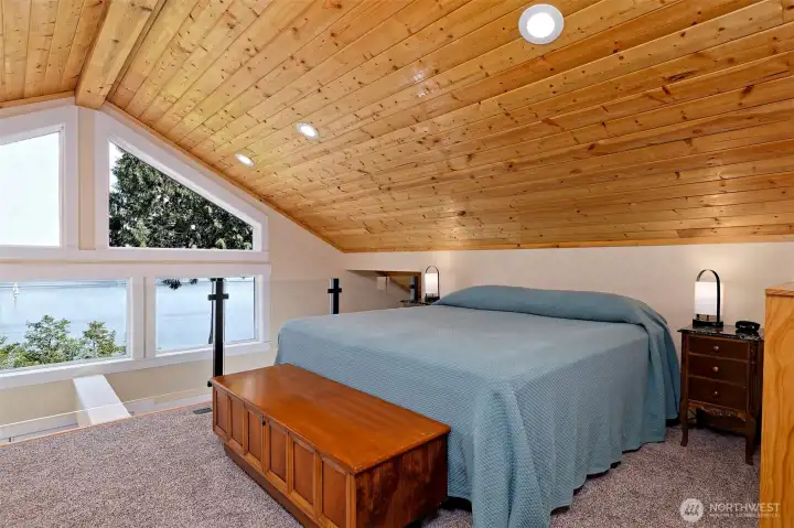 Loft bedroom with view and vaulted ceilings.