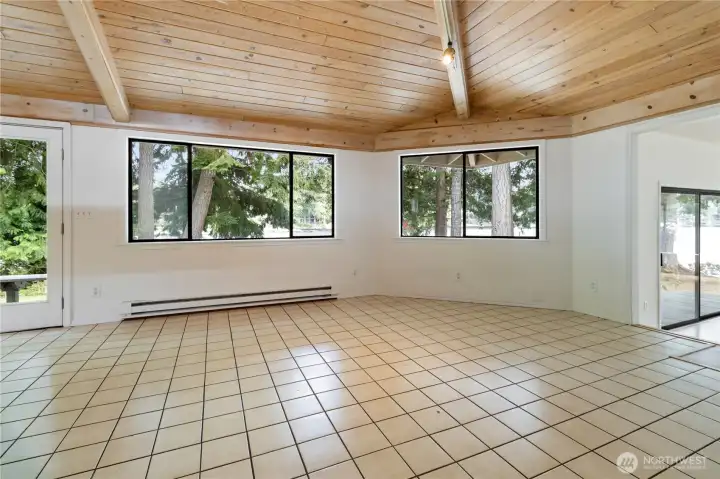 Dining room area with wood ceilings that are unique and bring in light.