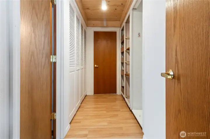 Hallway leading to bathrooms and bedrooms and laundry