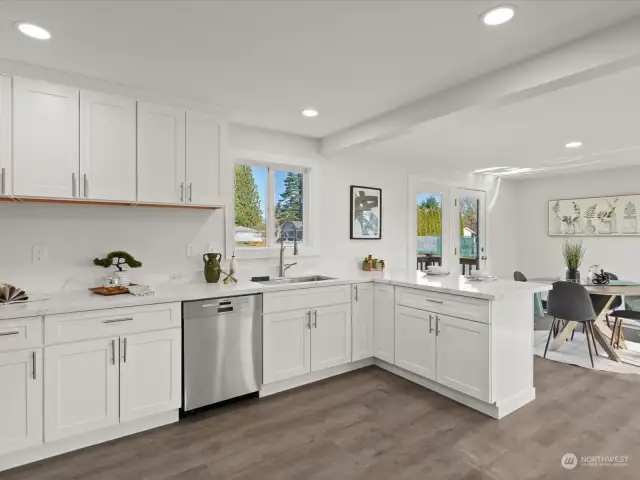 The light, bright kitchen is completely updated and includes beautiful quartz counters, soft close drawers, stainless appliances and a deep chef's sink.