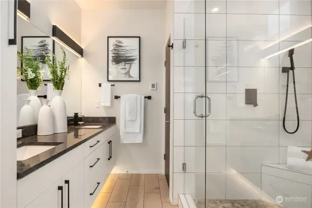 This spa-worthy en suite features extensive tile work, an enormous walk-in shower, dual vanities with under cabinet automatic lighting and a separate water closet.