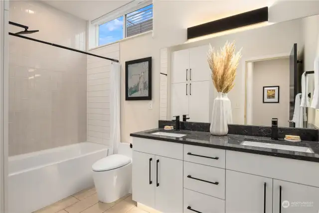 The main bathroom boasts a linen closet (to the right), 3 different types of tile and a dual vanity with under cabinet automatic lighting.