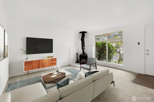 Large living room with wood-burning woodstove, newly painted interior and freshly cleaned carpets.