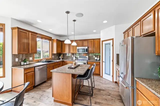 Granite counters, stainless appliances, and hardwoods flow into the open-concept design.