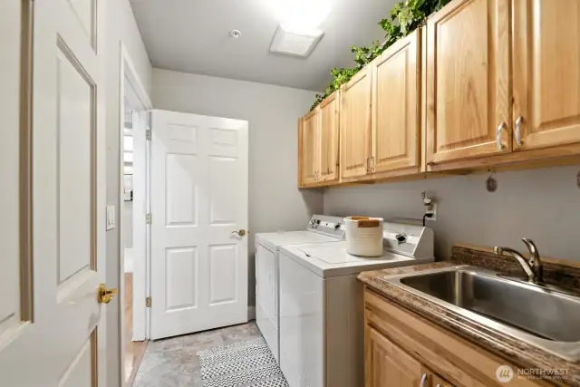 Excellent laundry room with plenty of storage adjacent to utility closest.