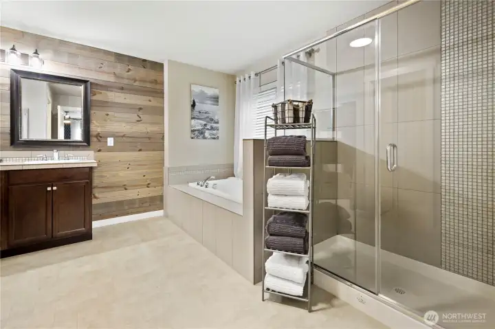 Owners' suite with large tile shower soaking tub double vanity