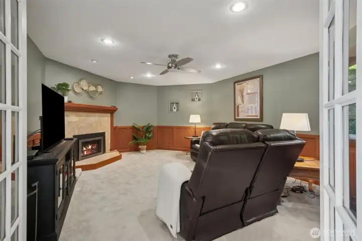 Inviting family room with gas, tiled fireplace with warm wood mantle, ceiling fan, and ample space for relaxing or entertaining.