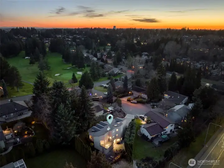 Sunset aerial view capturing the home and surrounding community.