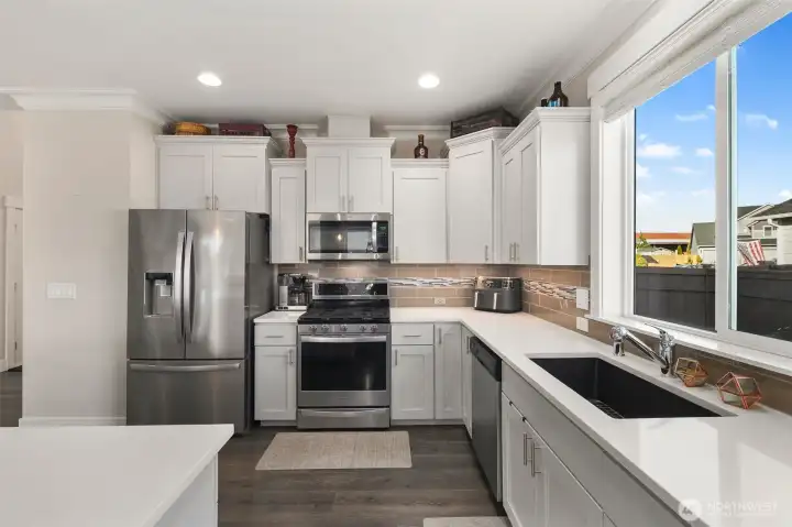 A spacious island anchors the kitchen, offering extra workspace and a place to gather, all within easy reach of the main living areas.