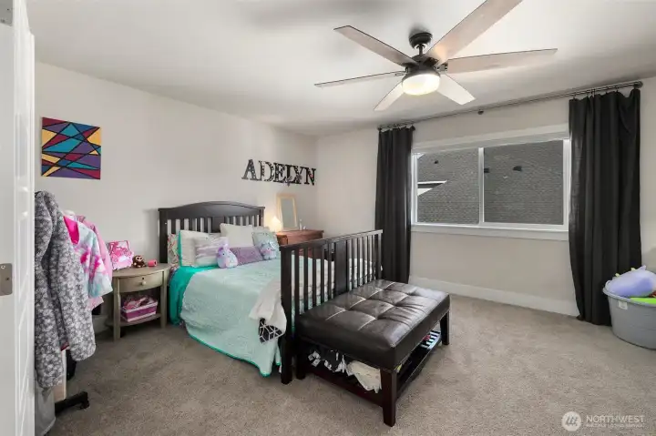 Spacious secondary bedroom with room for both sleeping and play, plus a large window that keeps the space feeling light and comfortable.