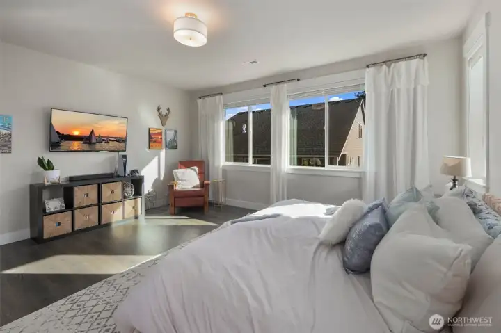 Light-filled primary bedroom with large windows and plenty of space to relax and unwind.