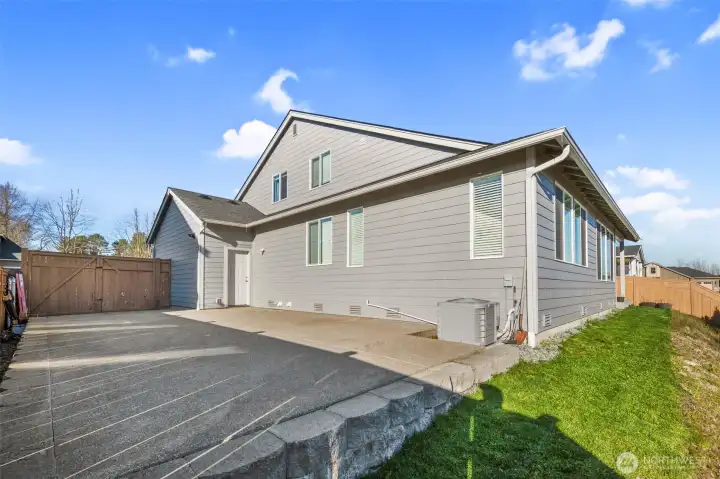 Spacious side yard with additional paved area, ideal for extra parking, storage, or recreational use.