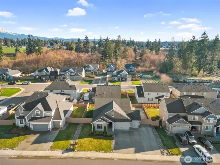 Front aerial perspective showcasing the home’s curb appeal and its place within a well-maintained community.
