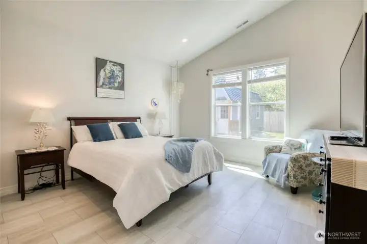 Spacious primary suite with vaulted ceilings and large windows that bring in natural light from your private back yard.