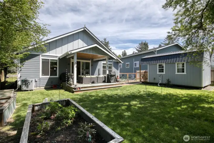 Fully fenced backyard with open lawn space and raised garden beds to grow flowers or veggies…or both!
