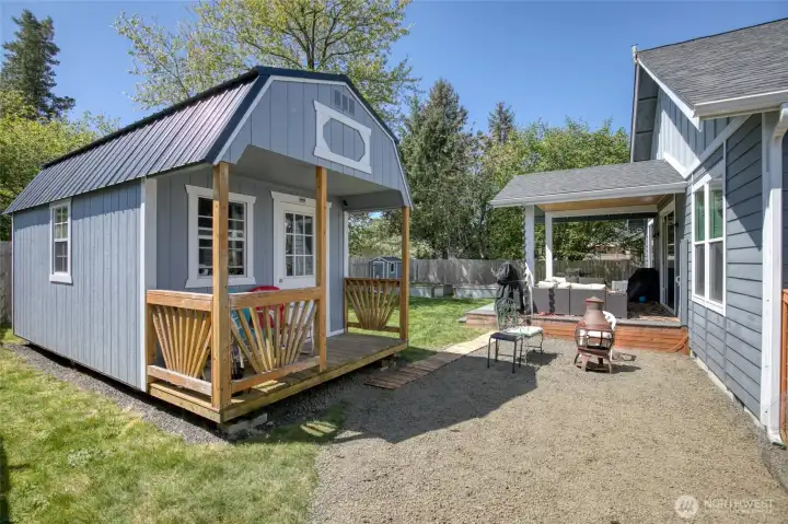 Spacious backyard with two outbuildings, a covered deck, and room to relax or gather.