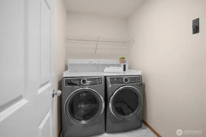 Upstairs laundry with custom folding counter + outlets.