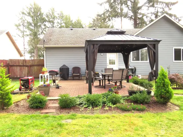 OUTSIDE IS A BRICK PATIO WITH GAZEBO SEATING AND MATURE GARDENS!