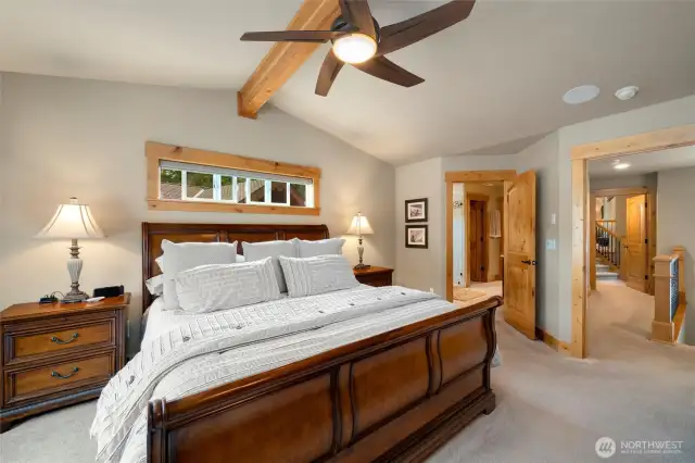 Primary bedroom with ceiling fan, motorized blinds, and ensuite