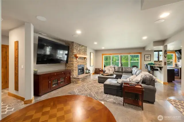 Daylight basement with gas fireplace, web bar, complete a mini fridge, double sliding glass doors leading to backyard