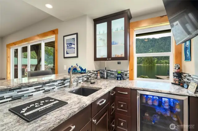Wet bar with granite countertops and eating bar