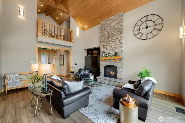 Floor to ceiling stone fireplace and catwalk add character to the room