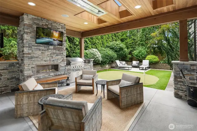 Covered outdoor living space with heaters, gas fireplace, built-in barbecue and TV