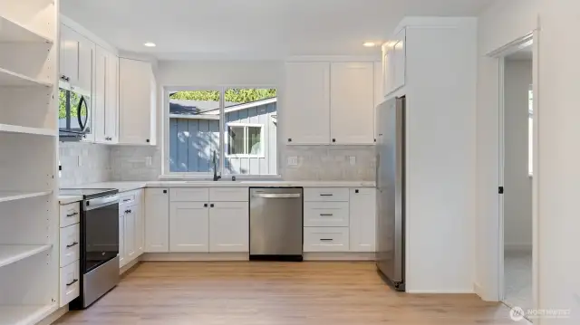 Kitchen has stainless appliances, including the fridge.